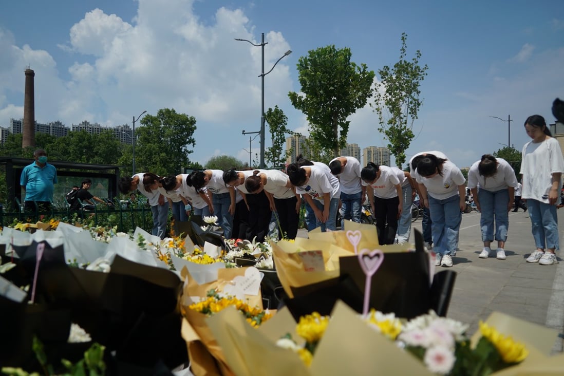 People bow to pay their respects outside the entrance to a subway station in Zhengzhou in central China's Henan Province, Tuesday, July 27, 2021. Photo: AP