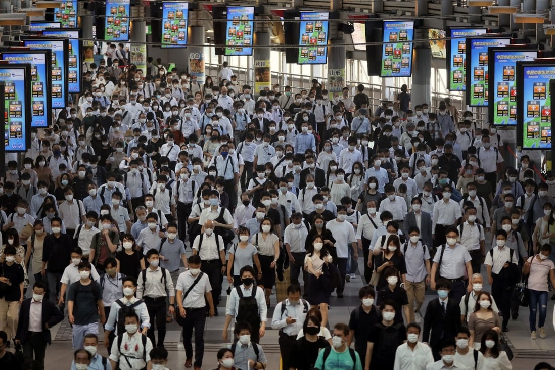 Commuters wearing face masks arrive at Shinagawa Station in Tokyo on Monday morning. While there are relatively few cases among athletes, infections are surging among the broader Tokyo population. Photo: Reuters