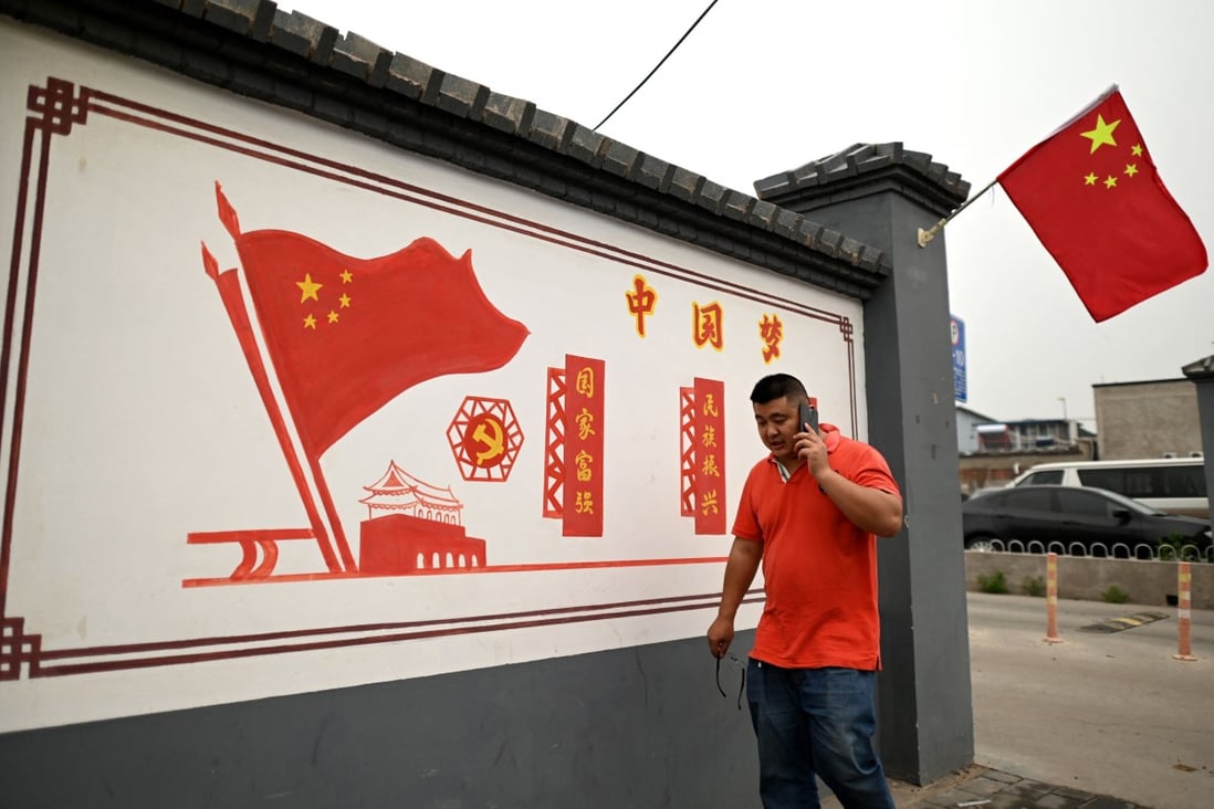 A man walking past a propaganda mural that reads "Chinese Dream: make the country prosperous and strong, rejuvenate the nation" along a street in Beijing. Photo: AFP