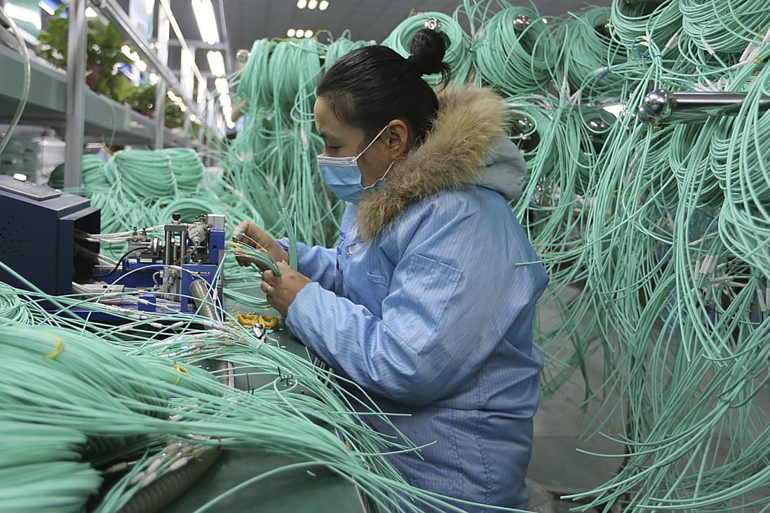 A worker assembles optic fibre cables at a factory in Suixi in central China's Anhui province. Photo: AP