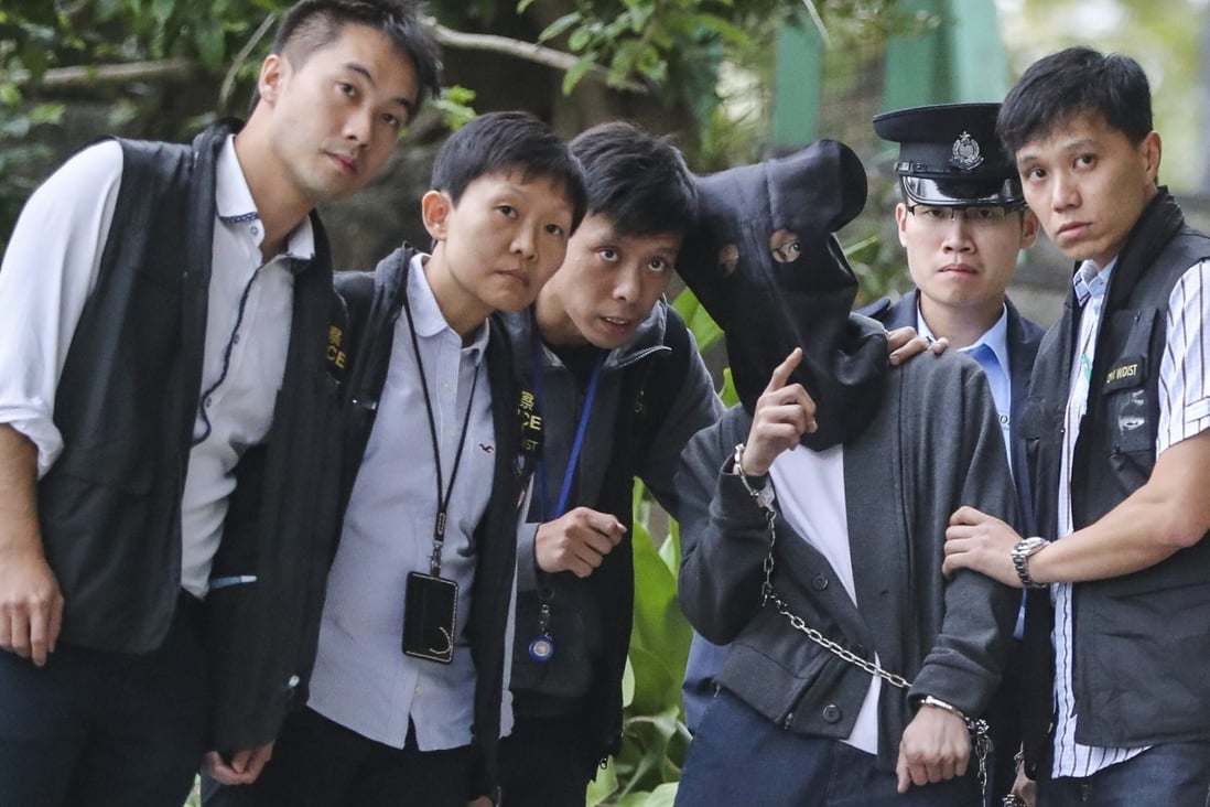 A hooded Lai Kan-yau is escorted by police to the crime scene to help gather evidence. Photo: Edward Wong