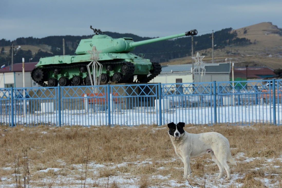 A dog stands in front of a Soviet IS-2 tank, a World War II monument, in the island chain known as the Southern Kurils in Russia and the Northern Territories in Japan. Photo: Reuters