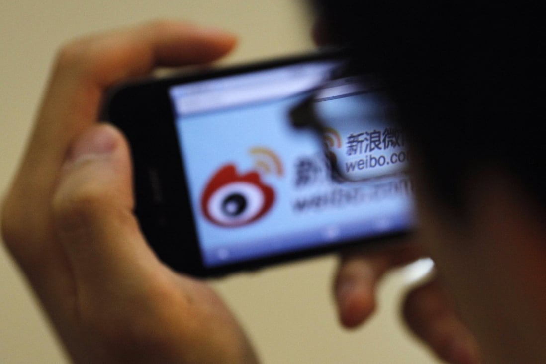 A man holds an iPhone as he visits Sina's Weibo microblogging site in Shanghai on May 29, 2012. Weibo’s former marketing and PR director has been arrested for allegedly accepting bribes, the company said in an internal memo, which did not reveal details about the case. Photo: Reuters
