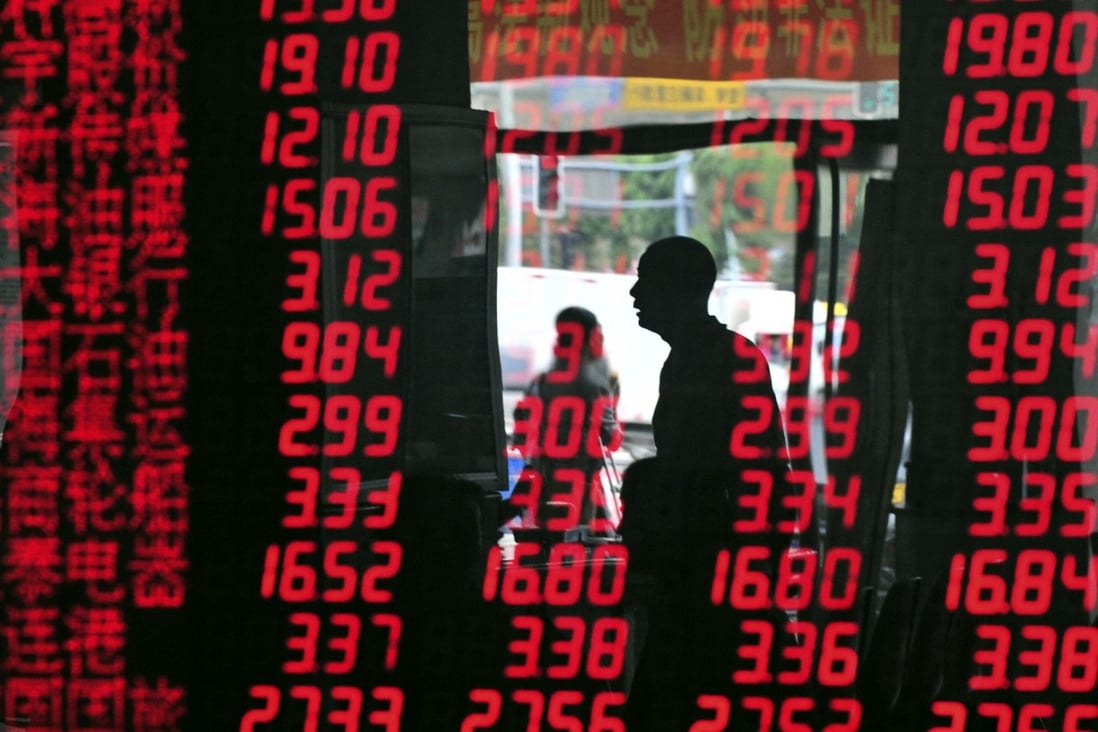 An investor is reflected in a screen showing stock information at a brokerage house in Shenyang, Liaoning province. China’s regulatory tentacles are reaching many industries, leaving investors to guess the extent of current crackdown. Photo: Reuters