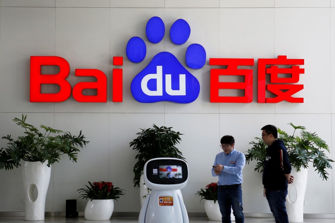 Men interact with a Baidu AI robot at its headquarters in Beijing. Photo: Reuters