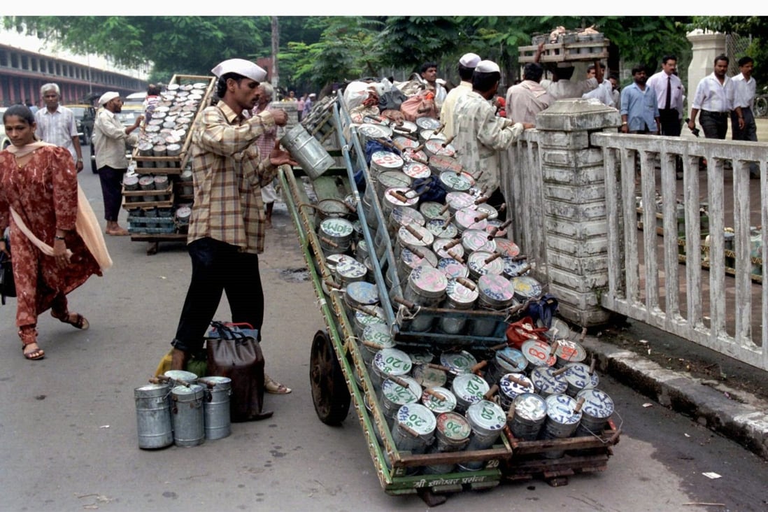 A tiffin delivery man loads lunchboxes onto a cart to deliver to office workers in Mumbai through a well-oiled logistical delivery operation. Photo: Reuters