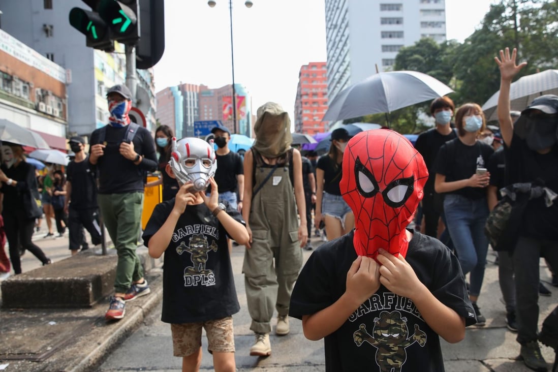 Two children wearing superhero masks take part in a march in Jordan on October 20, 2019. Photo: Winson Wong