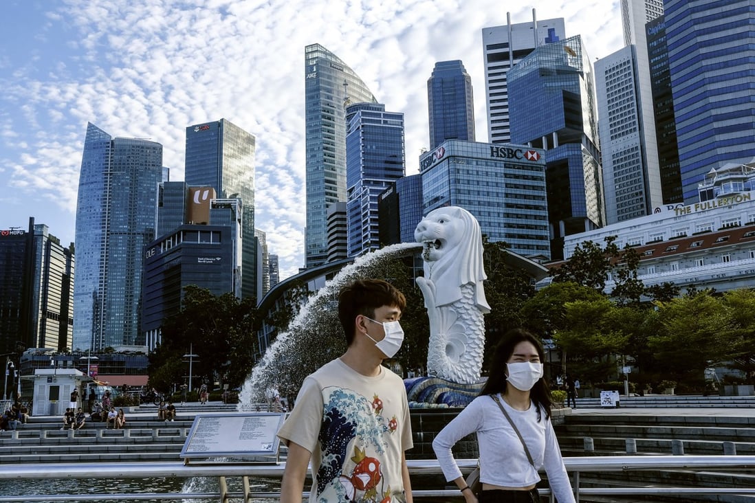 A couple in Singapore wear face masks while walking past the Merlion statue. Photo: AP