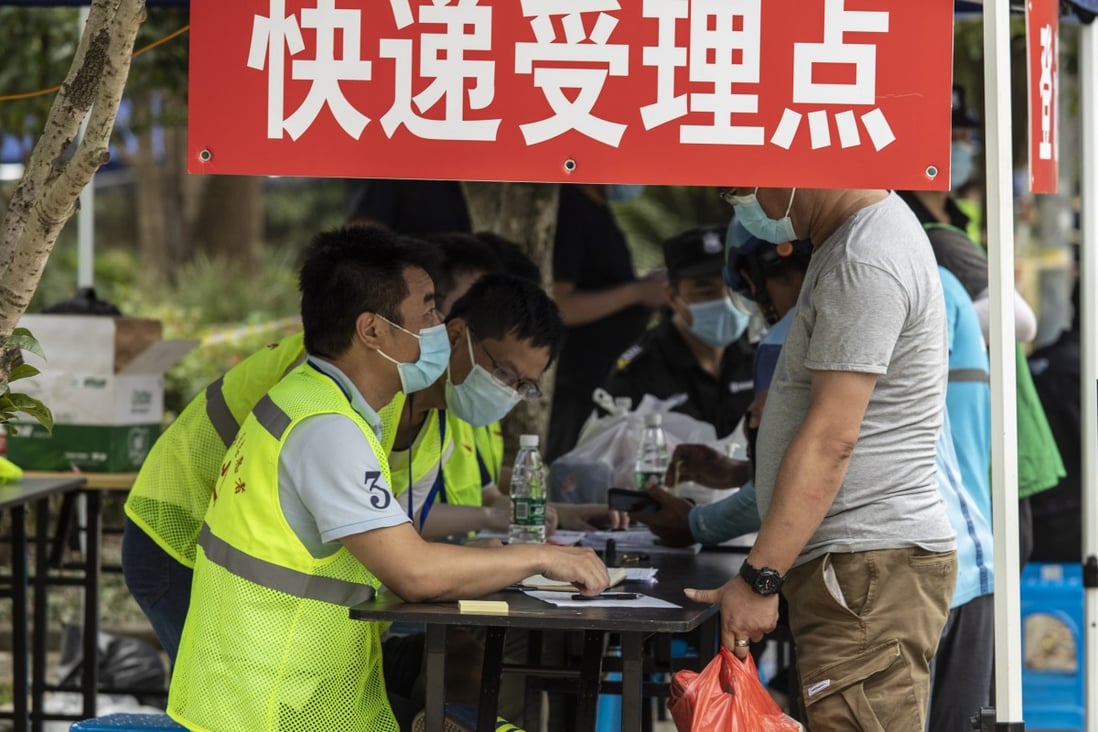 Volunteers and security guards help members of the public deliver food and other necessities to residents of a neighbourhood under lockdown in Shanghai on Saturday. Photo: Bloomberg