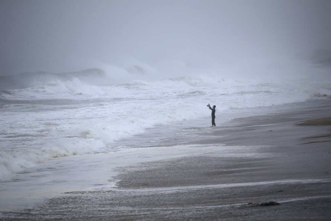 A resident of Westerly, Rhode Island takes photos of the waves as Tropical Storm Henri approaches on Sunday. Photo: AP
