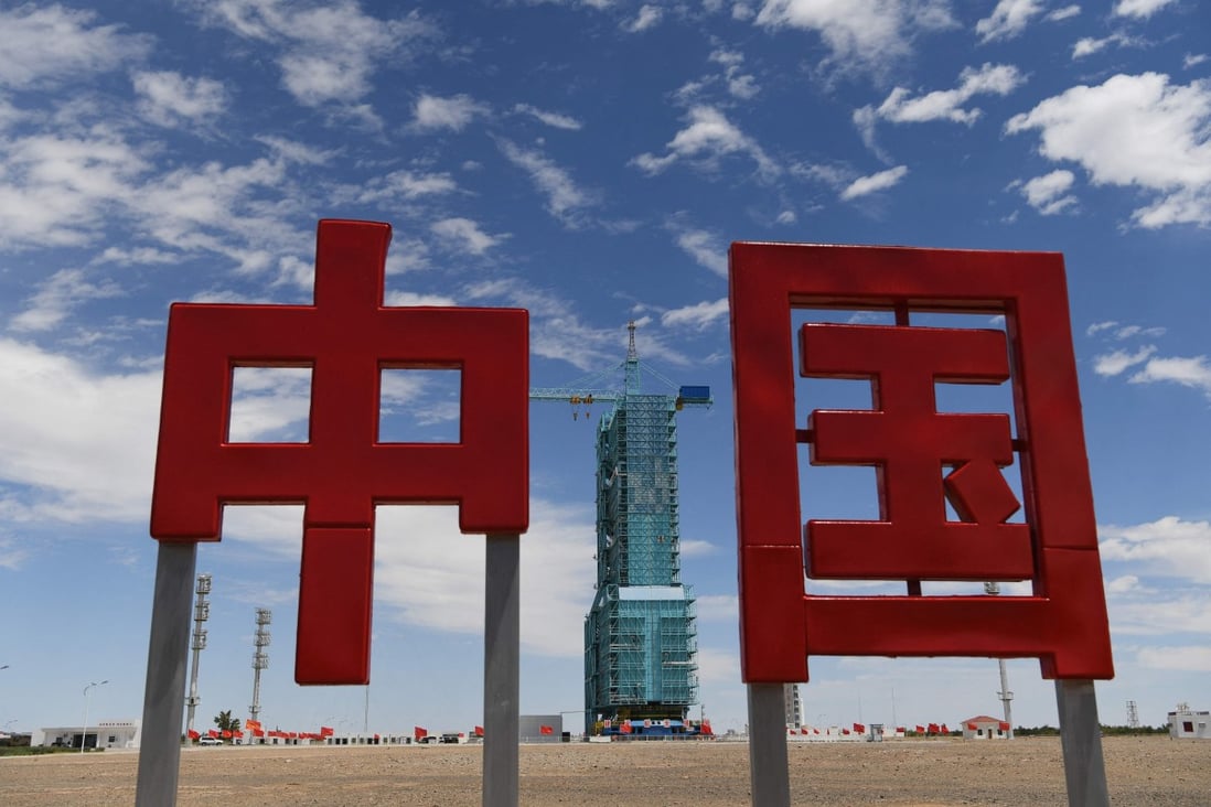 A Long March-2F carrier rocket, carrying the Shenzhou-12 spacecraft for the first Chinese crewed mission to its new space station, sits behind the characters for China at a satellite launch centre in the Gobi Desert on June 16. Photo: AFP