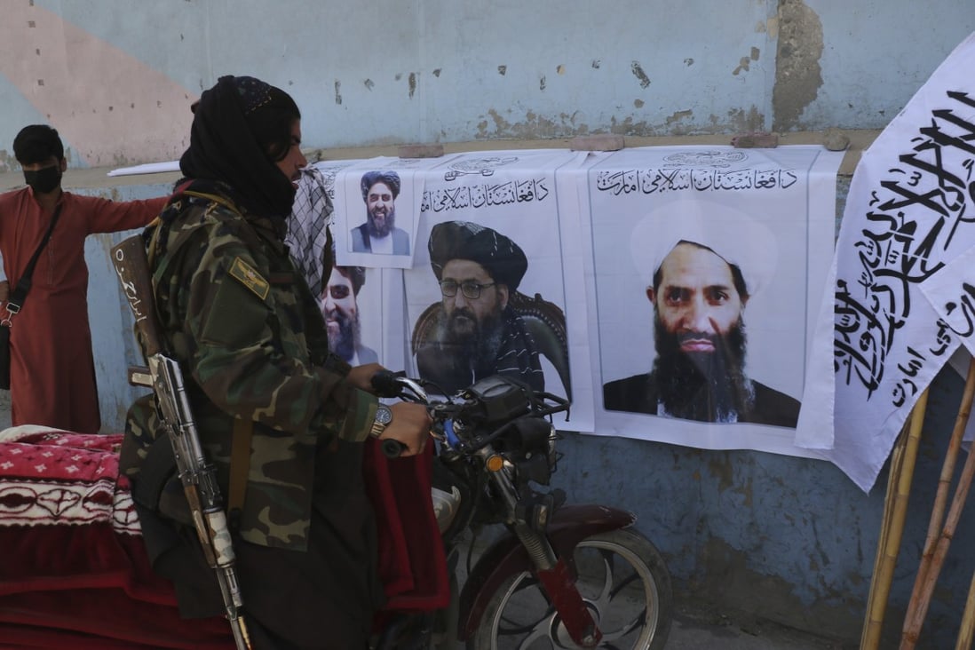 A Taliban fighter looks at Taliban flags and posters of leaders in Kabul, Afghanistan, on Wednesday. Photo: AP