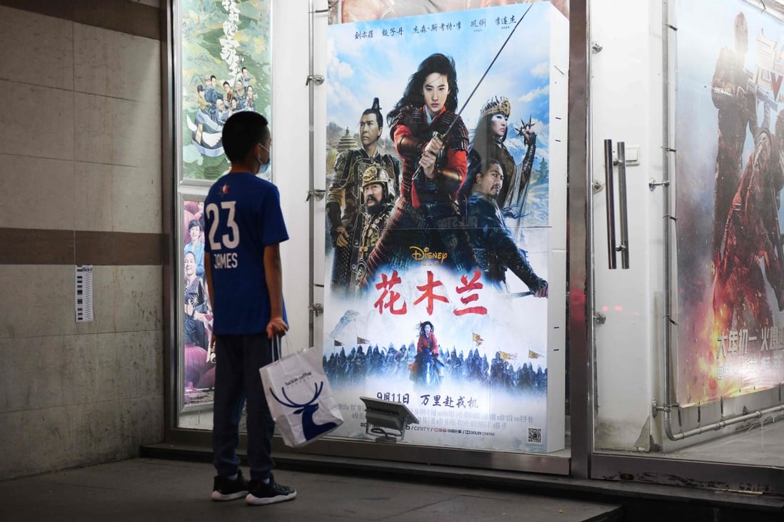 A boy looking at poster of the Disney movie “Mulan” outside a cinema on the day of its premiere in Beijing on September 11, 2020. Photo: AFP