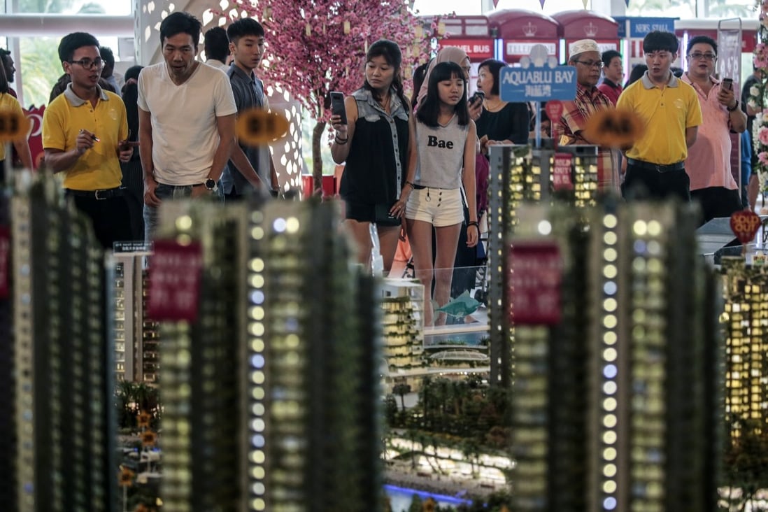 Potential buyers behind a scale model of Country Garden Holdings’ Forest City project in the Malaysian state of Johor, on 25 March 2018. Photo: EPA-EFE
