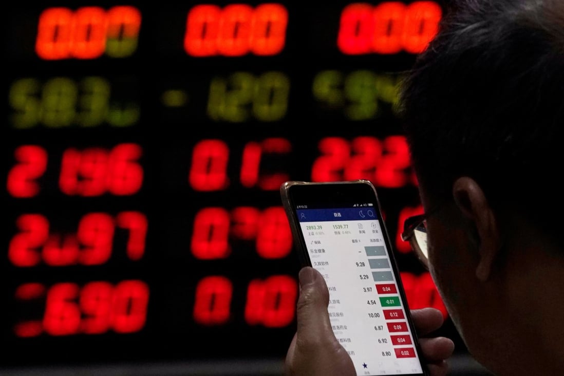 An investor checks stock information on a mobile phone at a brokerage house in Shanghai. Photo: Reuters
