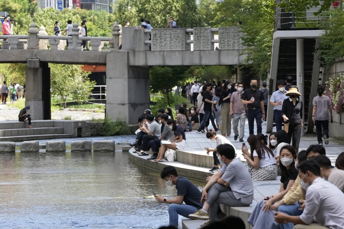 People sit at the Cheonggye Stream in Seoul. About 42.6 per cent of South Koreans are fully vaccinated. Photo: AP