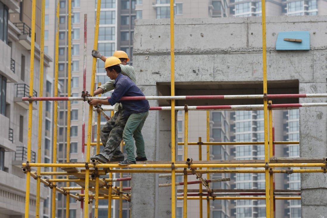 Construction workers assembling scaffolding on a housing complex in Beijing on August 15, 2017. Photo: AFP
