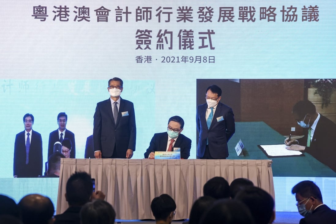Financial Secretary Paul Chan (left) and accounting sector representative Clement Chan (right) witness the signing of a new cooperation agreement on Wednesday. Photo: K. Y. Cheng