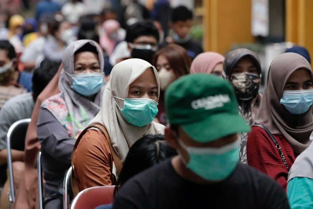 Indonesians queue up to receive a Covid-19 vaccine dose. After the government imposed vaccination requirements to enter many venues, there was a spike in the number of fake inoculation certificates, causing concerns about the credibility of the programme. Photo: Reuters