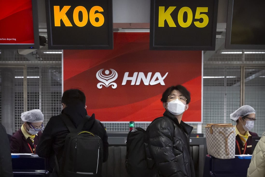 Travellers wearing face masks wait in line at Hainan Airlines’ check-in counters at Beijing international airport in March last year. Photo: AP Photo