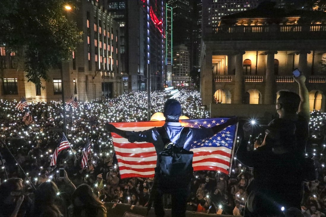 Anti-government protesters in Hong Kong wave a US flag during a demonstration in 2019. Photo: Felix Wong