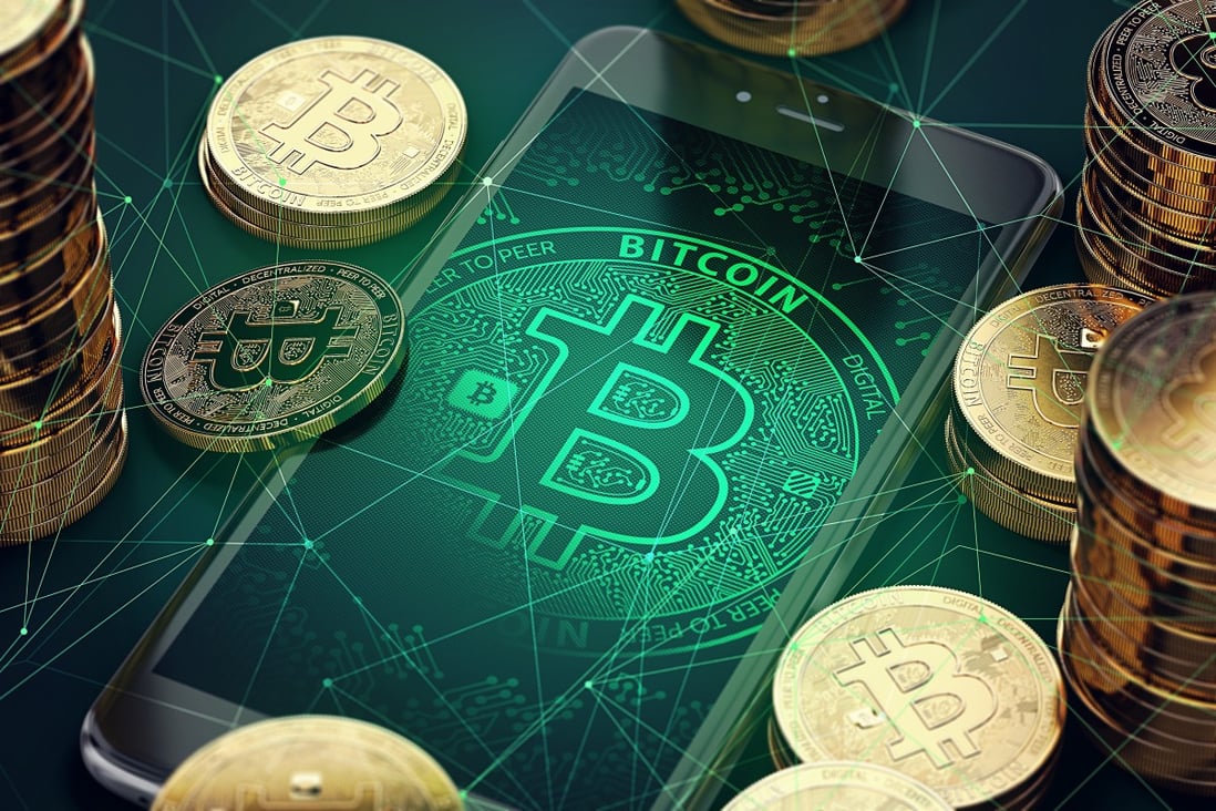 Smartphone with bitcoin symbol on-screen among piles of golden Bitcoins. Photo: Shutterstock