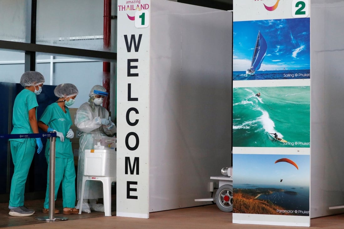 Health workers stand at the Covid-19 swab test area at the airport after Phuket reopened to vaccinated overseas tourists. Photo: Reuters