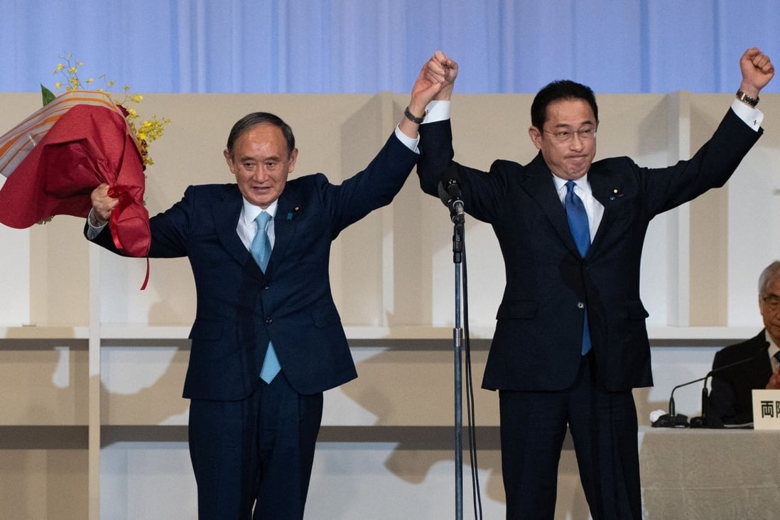 The LDP’s new leader Fumio Kishida (R) celebrates with outgoing PM Yoshihide Suga. Photo: AFP