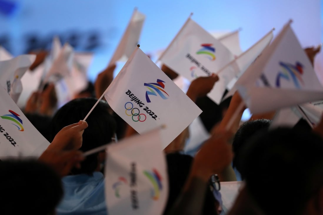 Attendees wave flags with the Beijing 2022 logo at a ceremony in Beijing on September 17. Photo: Reuters