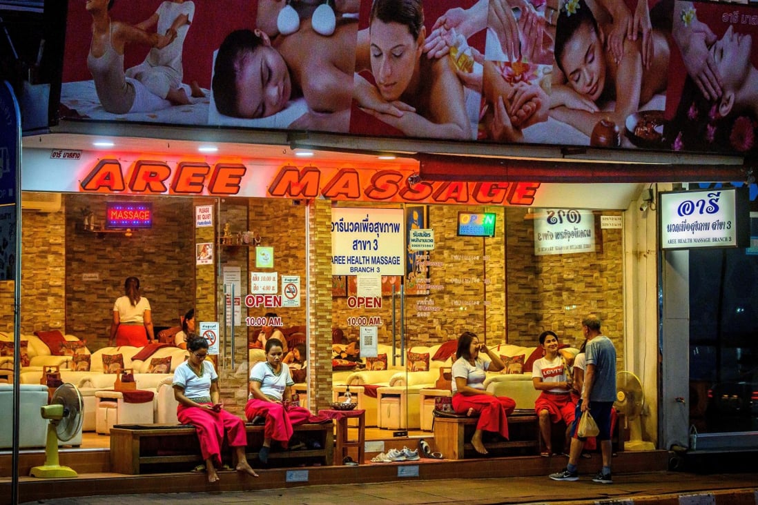 Employees wait for customers outside a massage parlour in Pattaya. Photo: AFP