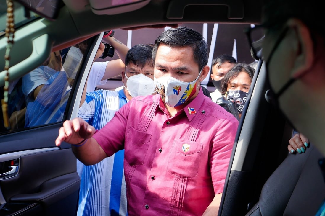 Senator and boxing icon Manny Pacquiao gets in a car on his way to file his candidacy to run for president. Photo: DPA