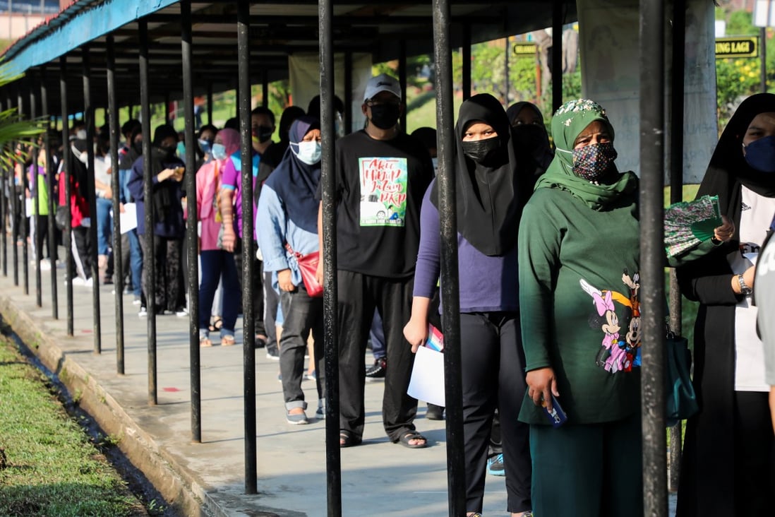 High school students and their parents wait in line to receive coronavirus vaccines at a school in Kuala Lumpur. Malaysia has fully vaccinated 63.8 per cent of the population, and 88.4 per cent of adults. Photo: Reuters