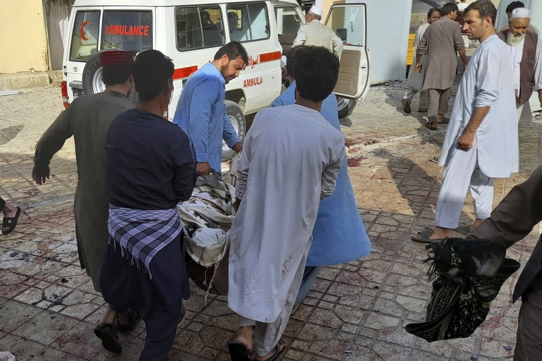 People carry the body of a bombing victim in Kunduz province, northern Afghanistan, on Friday. Photo: AP