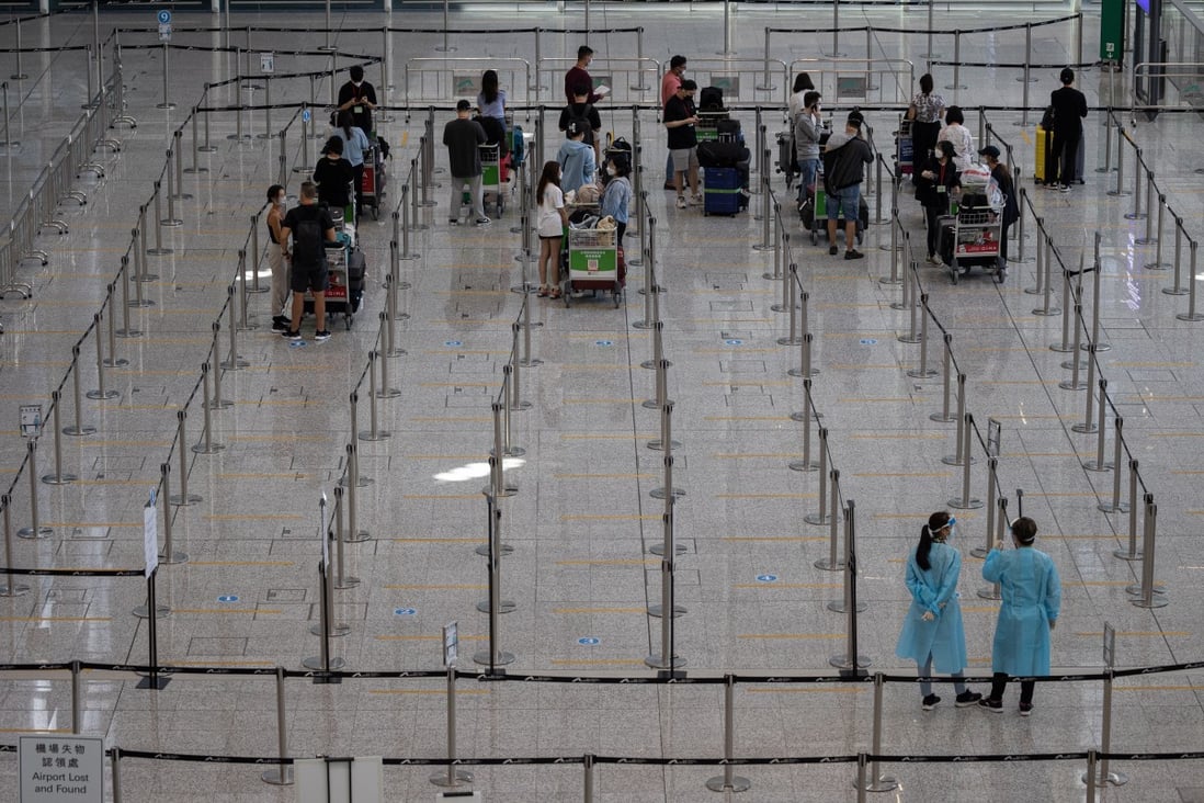 Travellers wait to be taken to government-designated quarantine hotels at Hong Kong International Airport. Photo: EPA-EFE