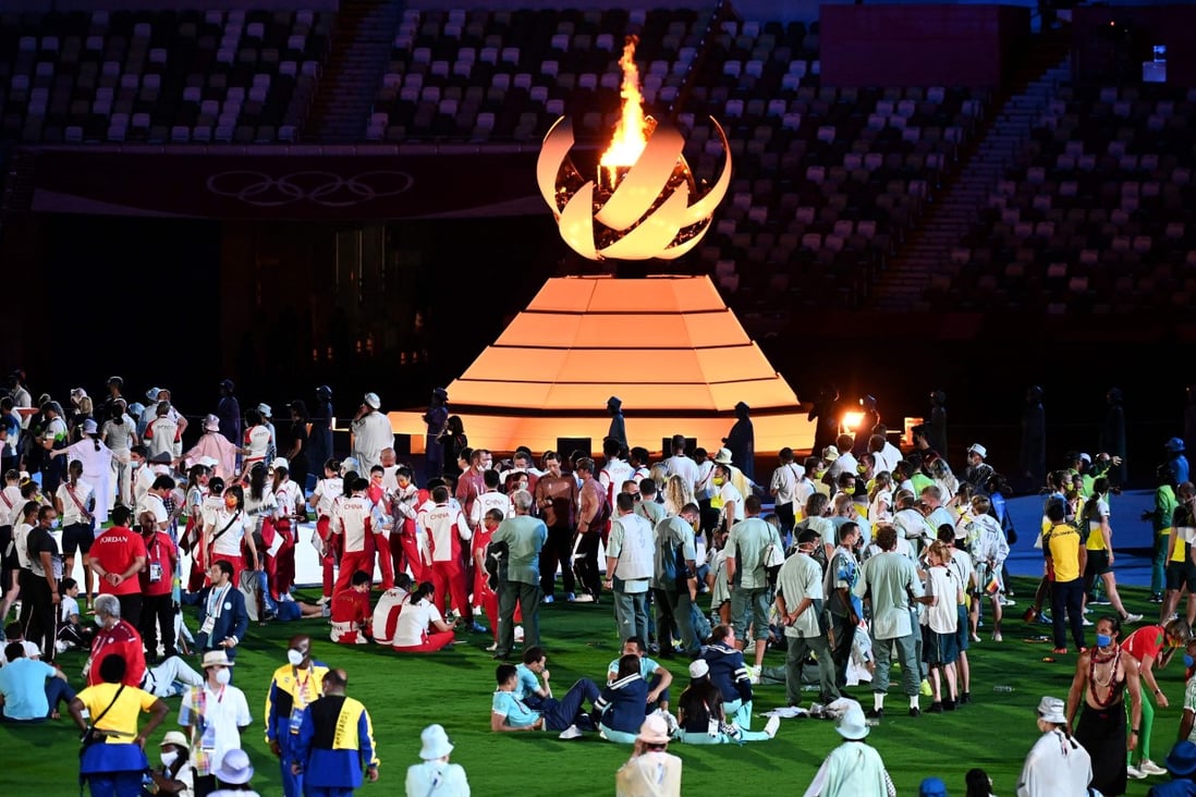 Athletes celebrate next to the Olympic cauldron and the Olympic flame during the closing ceremony of the Tokyo 2020 Summer Games, at the Olympic Stadium in Tokyo on August 8. Photo: AFP