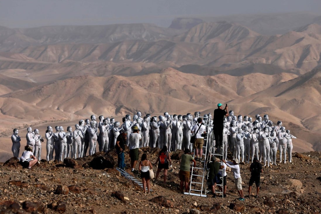 American art photographer Spencer Tunick and his crew work on a photo installation in the desert near the Israeli city of Arad on Sunday. Photo: Menahem Kahana / AFP
