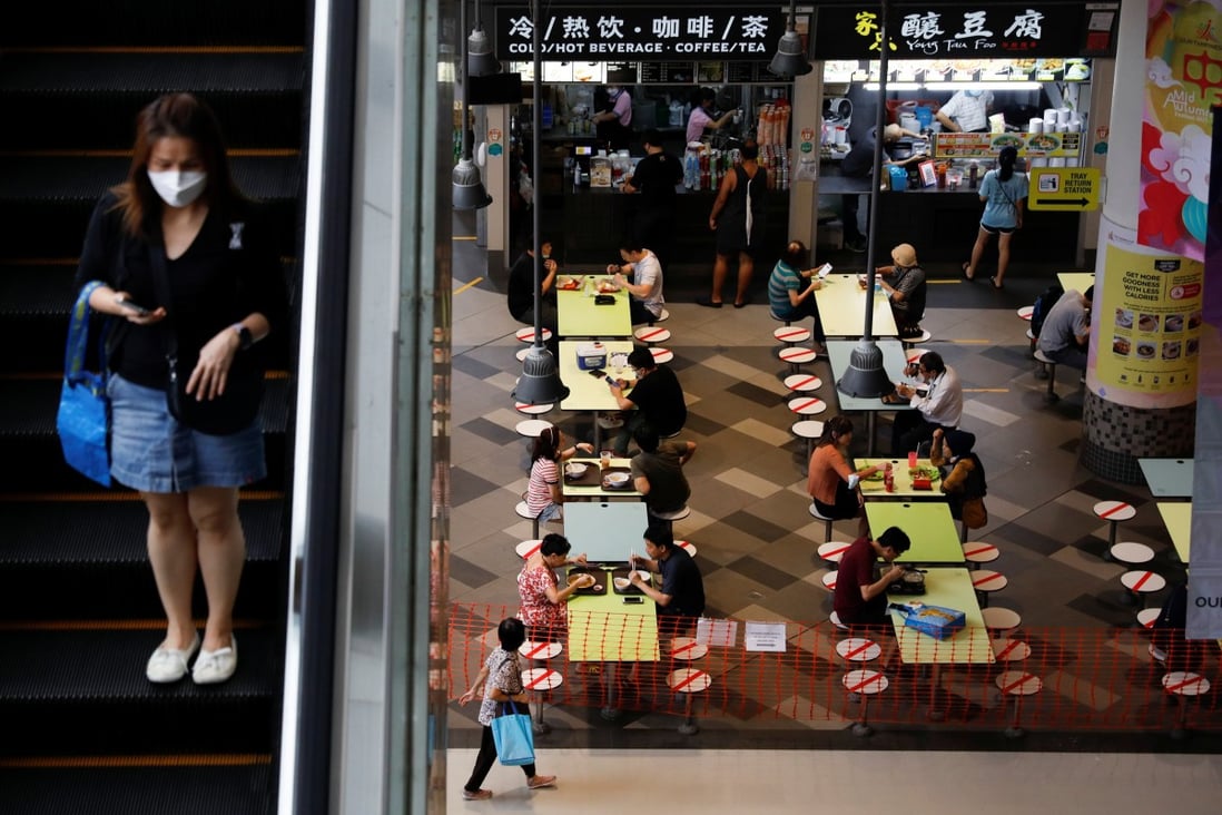 People dine in groups of two at a mall in Singapore; the restriction is now to stay until November 21. Photo: Reuters
