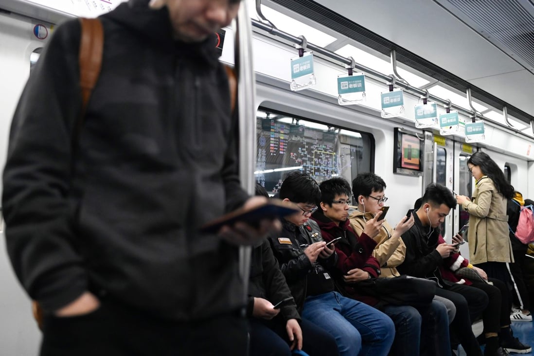 Commuters check their smartphones as they ride a subway in Beijing. The Cyberspace Administration of China’s latest draft proposal directs internet platform operators to ban re-registration of social media accounts that were previously closed for violating laws and regulations. Photo: Agence France-Presse
