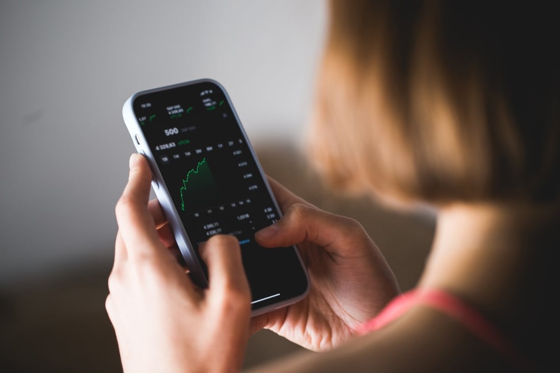 An investor looks at a stock chart on a smartphone. Internet brokerages like Futu and Tiger have come under the gaze of China’s central bank. Photo: Shutterstock