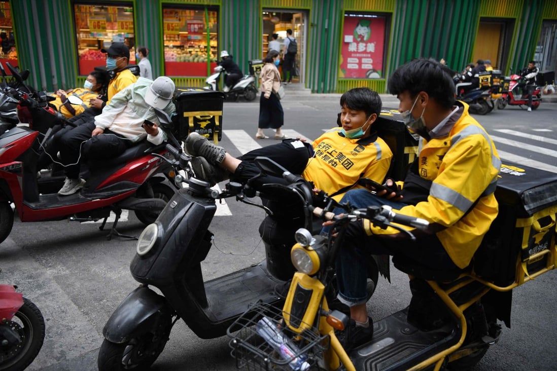 Delivery riders for Meituan, one of China's biggest food delivery firms, wait for orders outside a restaurant in Beijing on May 14, 2021. Photo: AFP
