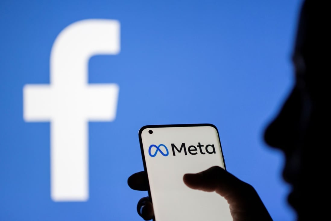 A woman holds a smartphone with Meta logo on it in front of a displayed Facebook logo. Photo illustration: Reuters