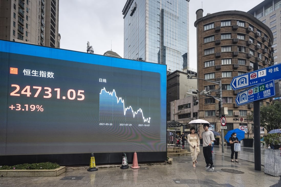 People stand next to a screen showing stock exchange and economic data in Shanghai. Photo: EPA-EFE