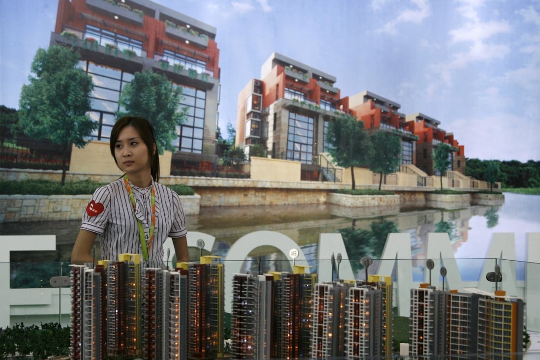 A sales agent and the model of a property development at the 5th China (Shenzhen) Real Estate Fair in Shenzhen on May 4, 2010. Photo: Reuters.