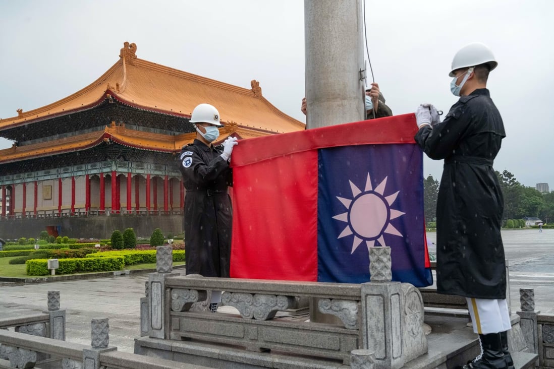 Honour guards wearing protective masks raise a Taiwanese flag at the National Chiang Kai-shek Memorial Hall in Taipei. Photo: Bloomberg