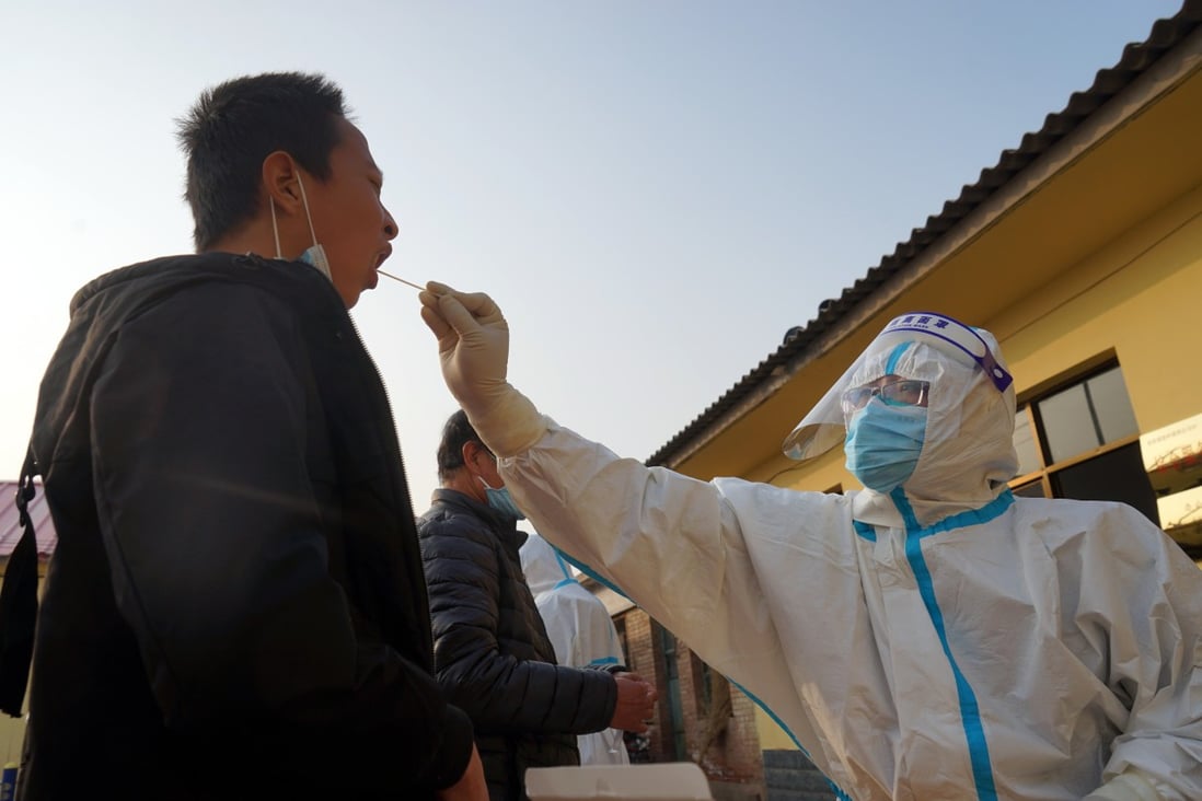 A medical worker takes a swab sample from a villager in Hebei’s Shenze county. Photo: Xinhua