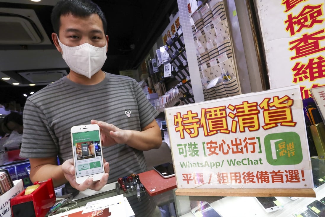 Peter Lau from JK Empire in Sham Shui Po displays a phone with the ‘Leave Home Safe’ app installed. Photo: Jonathan Wong