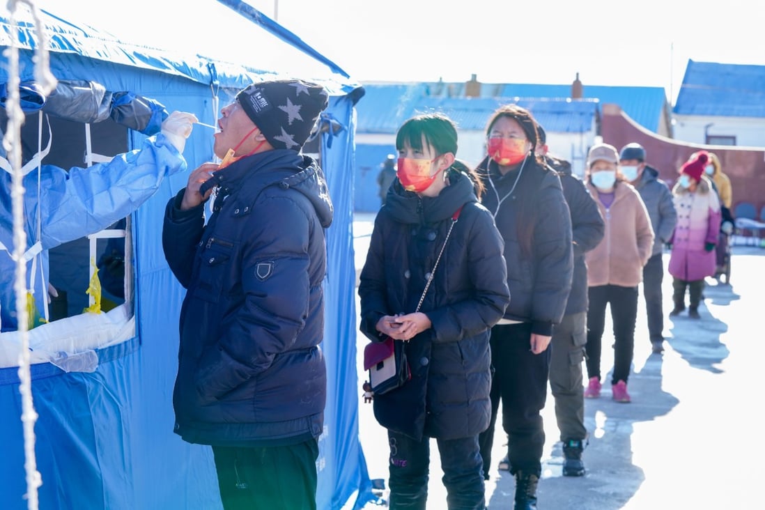 A medical worker takes a sample as people queue to be tested in the snow in Heilongjiang. Photo: Xinhua