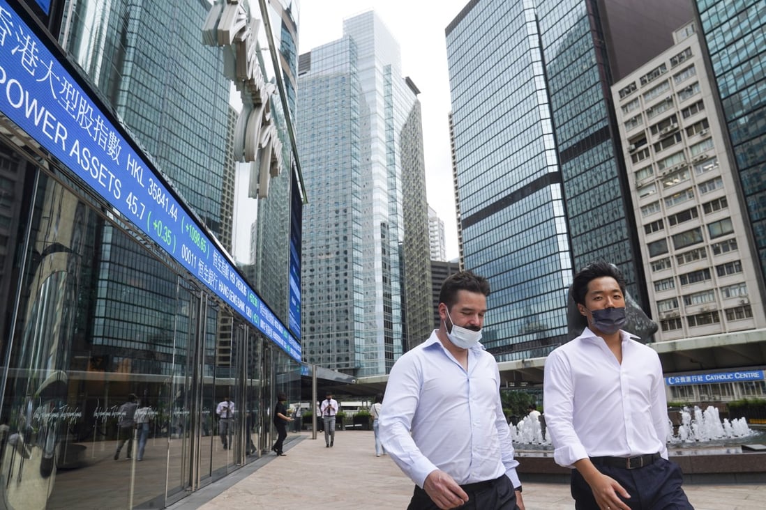 People walk past electronic board showing stock and index tickers at the Exchange Square in Central, Hong Kong on October 7. Photo: Sam Tsang