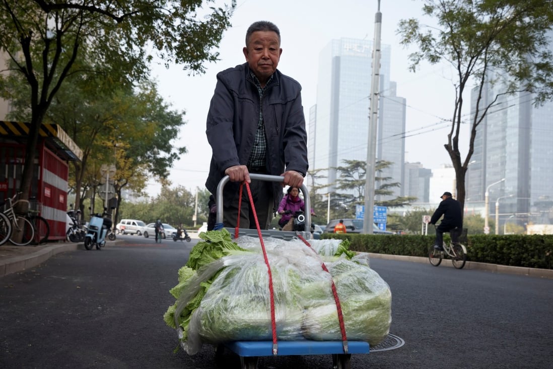 A Beijing resident stocks up on cabbages after the government issues a seasonal reminder about basic necessities. Photo: Reuters