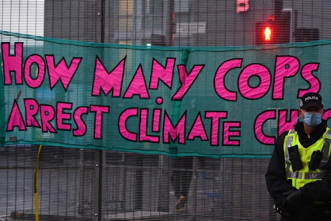A police officer monitors protesters during a climate change demonstration outside of the COP26 Climate Change Conference in Glasgow on November 12, 2021. Photo: AFP